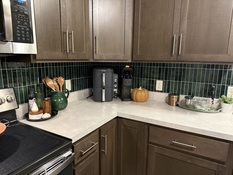 Corner counter after, with stacked green tile backsplash